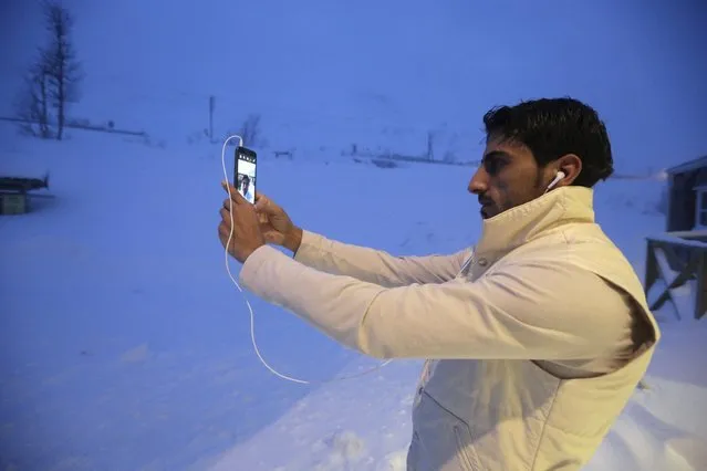 A refugee takes a selfie at the front of his camp at a hotel touted as the world's most northerly ski resort in Riksgransen, Sweden, December 15, 2015. (Photo by Ints Kalnins/Reuters)