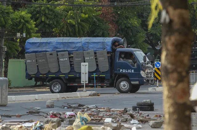 Policemen leave after vandalizing makeshift barricades made by anti-coup protesters in Yangon, Myanmar Thursday, March 11, 2021. Amnesty International accused Myanmar's military government on Thursday of increasingly using battlefield weapons against peaceful protesters and conducting systematic, deliberate killings. (Photo by AP Photo/Stringer)