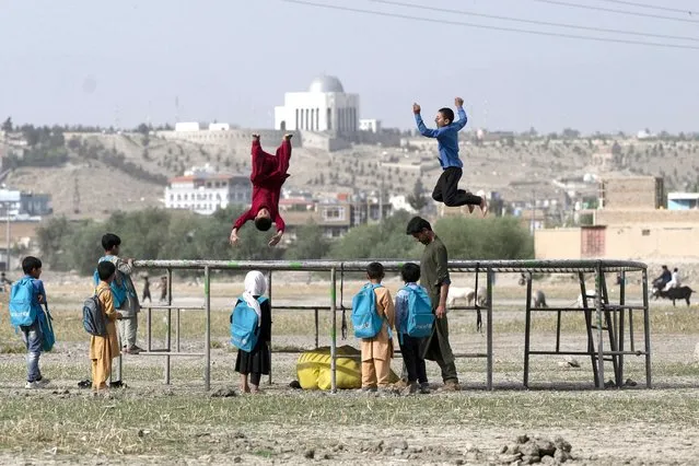 Afghan boys jump on a trampoline at Shuhada Lake in Kabul on June 19, 2023. (Photo by Wakil Kohsar/AFP Photo)