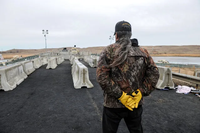 A member of the Oceti Sakowin camp security stands guard on Backwater Bridge during a protest against plans to pass the Dakota Access pipeline near the Standing Rock Indian Reservation, near Cannon Ball, North Dakota, U.S. November 27, 2016. (Photo by Stephanie Keith/Reuters)