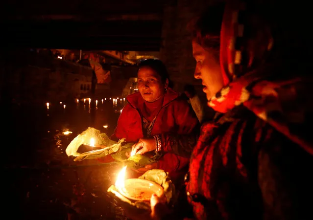 Devotees holding oil lamps perform religious ritual on the bank of Bagmati River flowing through the premises of Pashupatinath Temple, during the Bala Chaturdashi festival, in Kathmandu, Nepal November 28, 2016. (Photo by Navesh Chitrakar/Reuters)