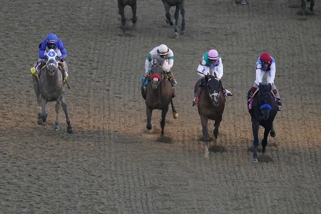 John Velazquez rides Medina Spirit, right, leads Florent Geroux on Mandaloun, Flavien Prat riding Hot Rod Charlie and Luis Saez on Essential Quality to win the 147th running of the Kentucky Derby at Churchill Downs, Saturday, May 1, 2021, in Louisville, Ky. (Photo by Charlie Riedel/AP Photo)