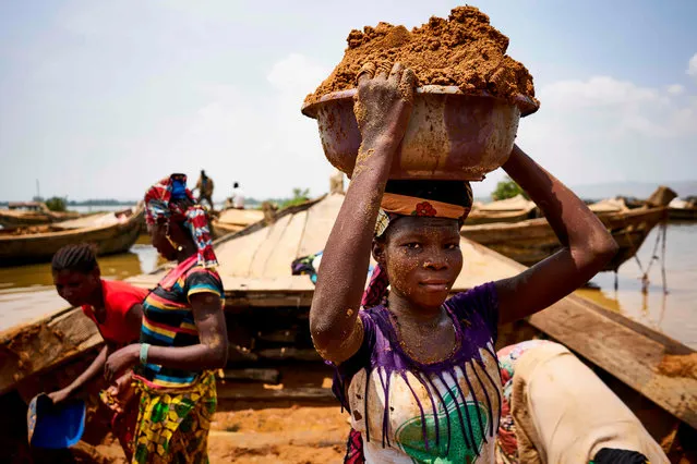 Malian women unload river sand from boats moored in the port of Bamako on October 1, 2018. (Photo by Michele Cattani/AFP Photo)