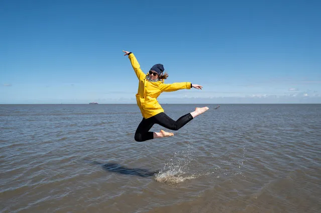 Tizia jumps at the beach following the ease of pandemic lockdown measures on May 23, 2021 in Cuxhaven-Duhnen, Germany. Authorities are easing lockdown measures across Germany, enabling restaurants to offer outdoor service, hotels to accommodate tourists, cultural institutions to perform and other activities to resume. Covid infection rates have been falling consistently and the national average is now below 75 per 100,000 over a seven-day period. Meanwhile the pace of vaccinations is climbing, with approximately 40% of the population having received a first dose. (Photo by David Hecker/Getty Images)