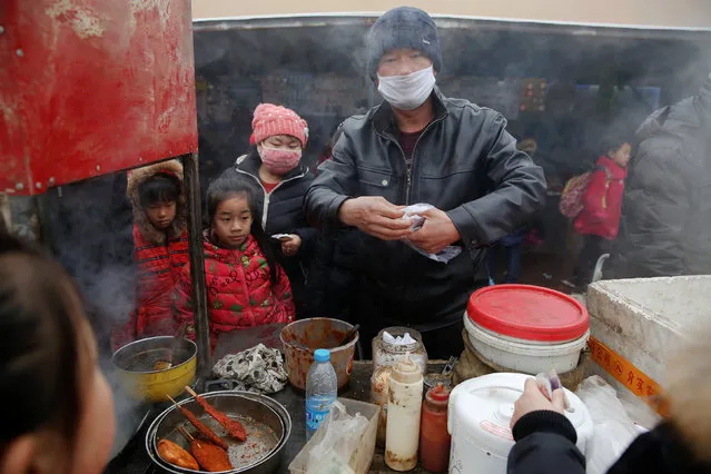 Children buy food outside their school as heavy smog blankets Shenfang in Hebei province, on an very polluted day December 20, 2016. (Photo by Damir Sagolj/Reuters)