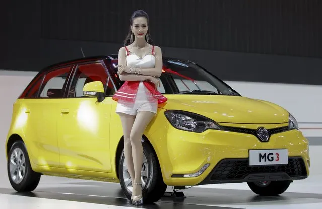 A model poses beside a MG3 during a media presentation of the 36th Bangkok International Motor Show in Bangkok March 24, 2015. (Photo by Chaiwat Subprasom/Reuters)