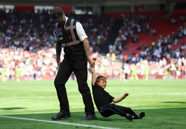 A young pitch invader is removed from the pitch after the Southampton v Manchester United Premier League match at St Mary's Stadium in Southampton, Britain on August 27, 2022. (Photo by Hannah Mckay/Reuters)