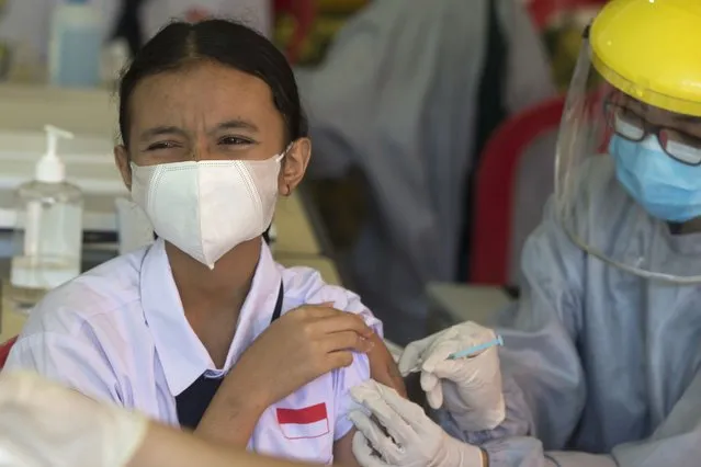 A teenager reacts as she receives a shot of the Sinovac vaccine for COVID-19 during a vaccination campaign at a school in Denpasar, Bali, Indonesia on Monday, July 5, 2021. (Photo by Firdia Lisnawati/AP Photo)