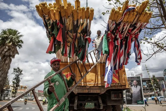 Nairobi City County workers get ready to unload a truck with flags of Kenya and the United Kingdom as they install them in the streets ahead of the Britain's monarch visit to Kenya in Nairobi on October 30, 2023. Britain's King Charles III and his wife Queen Camilla are set to take part on a four-day state visit to Kenya starting on October 31, 2023, in what is expected to be their first visit to a Commonwealth nation since their coronation. (Photo by Luis Tato/AFP Photo)