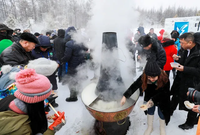Visitors enjoy a hotpot in subzero temperatures at the opening ceremony of a “Pole of Cold” festival in Genhe, Inner Mongolia, China on December 25, 2018. (Photo by Reuters/China Stringer Network)