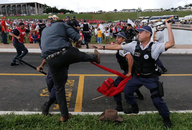 A demonstrator clashes with military police officers during a protest in Brasilia, Brazil, Tuesday, April 7, 2015. (Photo by Eraldo Peres/AP Photo)