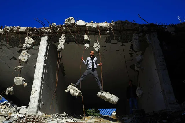 Palestinians play in the ruins of a building that was destroyed in the 2014 war between Israel and Hamas militants, in Gaza City, on February 16, 2016. (Photo by Mohammed Abed/AFP Photo)