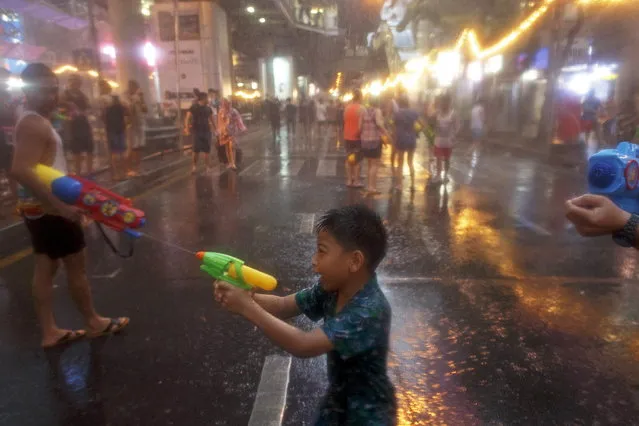 A child uses a water gun as he participates in a water fight during Songkran Festival celebrations at Silom road in Bangkok April 12, 2015. (Photo by Athit Perawongmetha/Reuters)