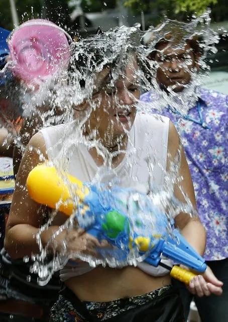 A tourist gets sprayed with water during the Songkran festival, the Thai traditional New Year, also known as the water festival on the popular tourist strip of Khao San road in Bangkok, Thailand, 12 April 2015. (Photo by Narong Sangnak/EPA)