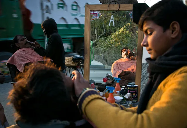 Pakistani customers have their beards shaved at a roadside barber shop in Islamabad, Pakistan, Tuesday, January 19, 2016. (Photo by B.K. Bangash/AP Photo)