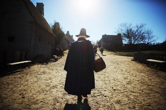 A historical performer playing the role of Goodwife Billington walks through in the 17th century English village at the Plimoth Patuxet Museums ahead of the Thanksgiving holiday in Plymouth, Massachusetts, U.S., November 21, 2022. (Photo by Brian Snyder/Reuters)