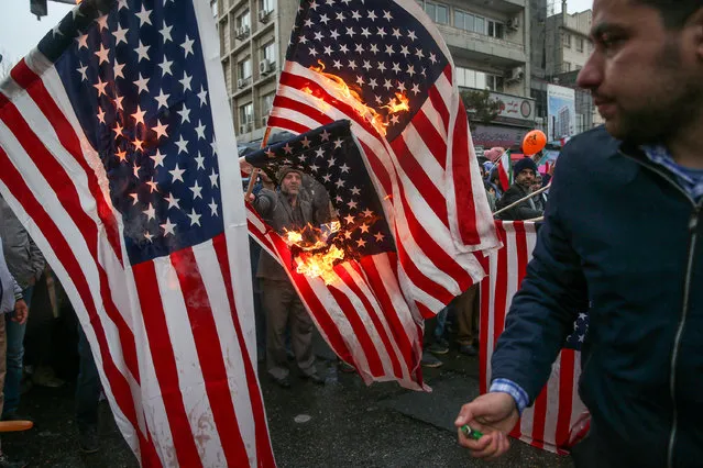 Iranians burn U.S. flags during a ceremony to mark the 40th anniversary of the Islamic Revolution in Tehran, Iran February 11, 2019. (Photo by Meghdad Madadi/Tasnim News Agency via Reuters)