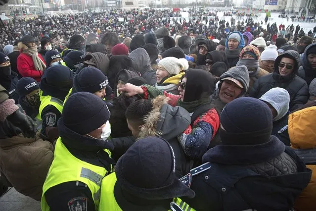 Protesters surge near a police line near the State Palace on Sukhbaatar Square in Ulaanbaatar in Mongolia on Monday, December 5, 2022. Protesters angered by allegations of corruption linked to Mongolia's coal trade with China have stormed the State Palace in the capital, demanding dismissals of officials involved in the scandal. (Photo by Alexander Nikolskiy/AP Photo)