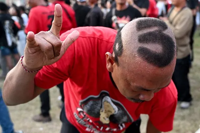 Central Java's former governor and presidential candidate Ganjar Pranowo's supporter cuts his hair at a campaign rally in Denpasar at Indonesia's resort island of Bali on January 20, 2024. In an upscale area of the capital Jakarta, Ganjar Pranowo says he can win Indonesia's upcoming election against the odds by focusing on bread-and-butter issues, a lesson learned from his upbringing in a mountainside village. (Photo by Sonny Tumbelaka/AFP Photo)
