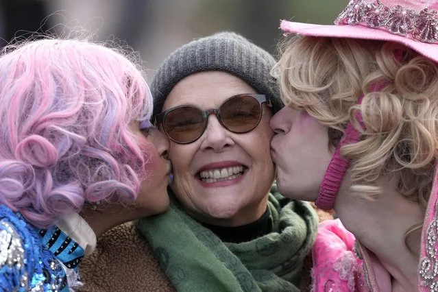 Actor Annette Bening, center, Hasty Pudding 2024 Woman of the Year, receives a kiss from Harvard University theatrical students Nikita Nair, left, and Joshua Hillers, right, while riding in a convertible during a parade, Tuesday, February 6, 2024, through Harvard Yard, in Cambridge, Mass. The award was presented to Bening by Hasty Pudding Theatricals, a theatrical student society at Harvard University. (Photo by Steven Senne/AP Photo)