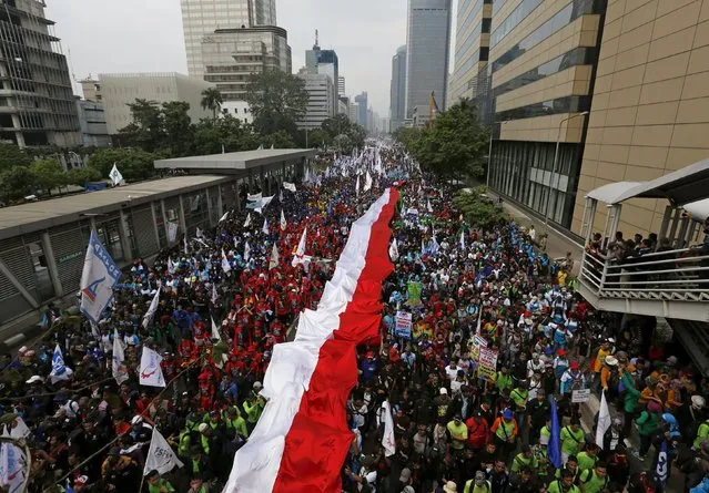 People carry a national flag as they march during a May Day rally in Jakarta, Indonesia, May 1, 2015. (Photo by Reuters/Beawiharta)