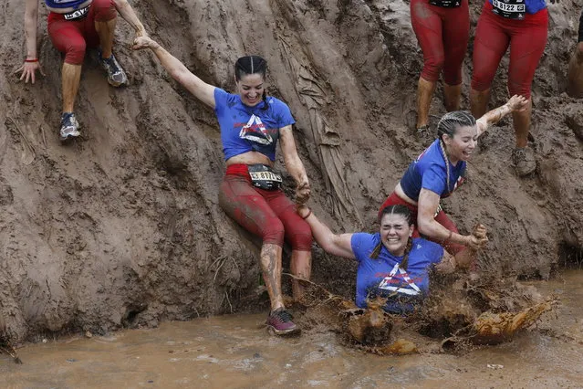 Participants make their way through muddy water during the Tel Aviv Mud Run race in the Yarkon Park, in Tel Aviv, Israel, 29 March 2019. Over 6,000 participants took part in the obstacle race, with up to 18 artificial obstacles on three tracks (10 km, five km or two km). (Photo by Abir Sultan/EPA/EFE)