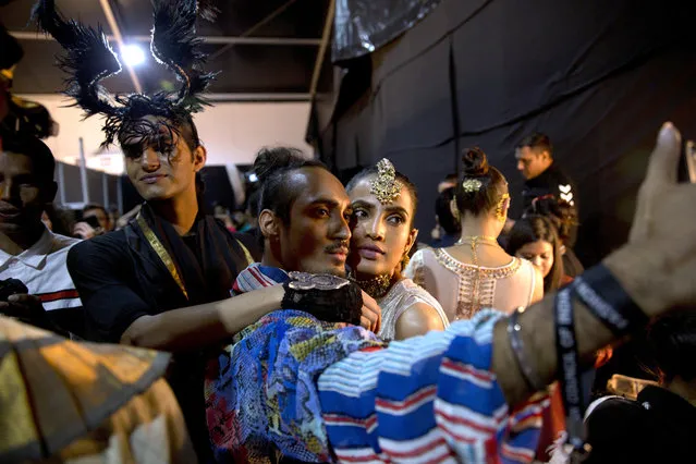 In this Saturday, March 16, 2019, photo, a designer takes a selfie with a model before the start of a catwalk during the Lotus Makeup India Fashion Week, in New Delhi, India. (Photo by Manish Swarup/AP Photo)