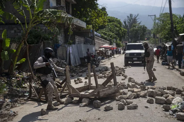 Police remove a roadblock set by protesters in Port-au-Prince, Haiti, Monday, October 18, 2021. (Photo by Joseph Odelyn/AP Photo)