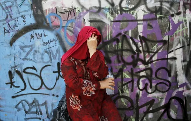 An Indonesian Muslim woman holds a bottle of water as she takes a break during shopping at Tanah Abang weekly Muslim market in Jakarta, May 7, 2015. (Photo by Reuters/Beawiharta)