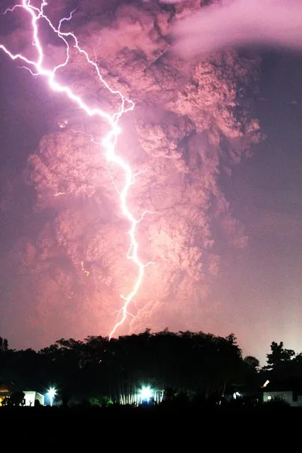 Volcanic cloud is seen from the eruption of Mount Kelud volcano as lightning strikes above the Blitar city on February 13, 2014 in Indonesia. (Photo by ANDIKA/Panjalu Images/Barcroft Media)