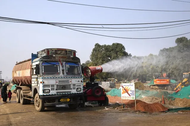 An anti-smog gun is used to control dust at a construction side in New Delhi, India, Thursday, November 18, 2021. Air pollution remained extremely high in the Indian capital on Thursday, a day after authorities closed schools indefinitely and shut some power stations to reduce smog that has blanketed the city for much of the month. (Photo by Manish Swarup/AP Photo)