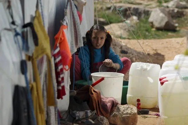 An internally displaced girl washes clothes inside a refugee camp in Dana town after fleeing Palmyra, in northern Idlib province, Syria April 2, 2016. (Photo by Khalil Ashawi/Reuters)