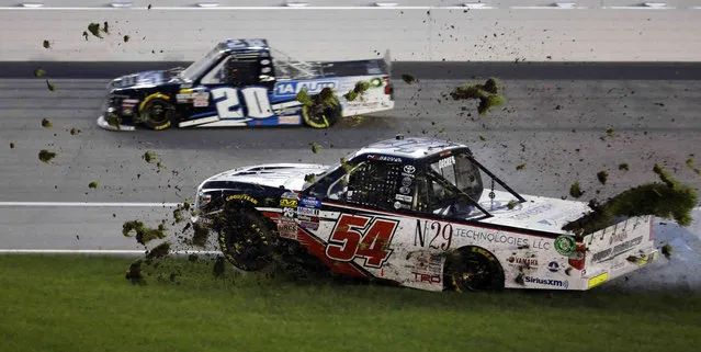 Natalie Decker (54) spins into the infield grass during the NASCAR Truck Series auto race at Kansas Speedway in Kansas City, Kan., Friday, May 10, 2019. Harrison Burton (20) gets by on the outside. (Photo by Colin E. Braley/AP Photo)