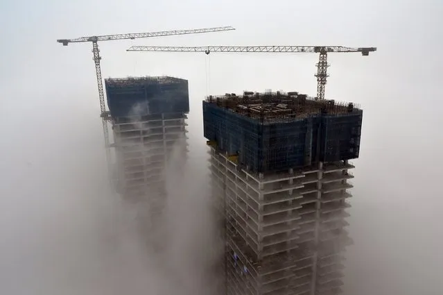 Buildings under construction are seen among fog in Rizhao, Shandong province, China, May 19, 2015. (Photo by Reuters/Stringer)