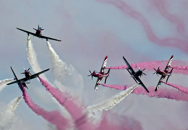 An aerobatics team performs over Qatar's capital Doha as the Gulf state marks its National Day on December 18, 2021. Qatar annually on December 18 marks the anniversary of the unification of the country's tribes in 1878, also known as its “Founder's Day”. (Photo by AFP Photo/Stringer)