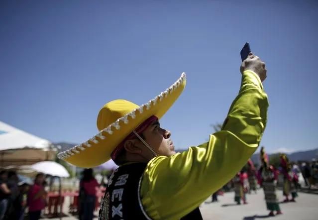 A Matachin dancer takes a selfie while participating in a religious festival in Saltillo, Mexico, April 17, 2016. (Photo by Daniel Becerril/Reuters)