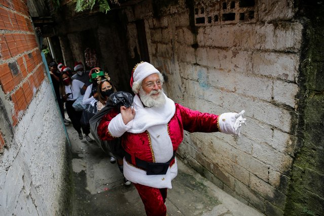 A man dressed as Santa Claus takes part in a Christmas toy distribution organized by a Venezuelan journalists group, in Caracas, Venezuela on December 17, 2021. (Photo by Leonardo Fernandez Viloria/Reuters)