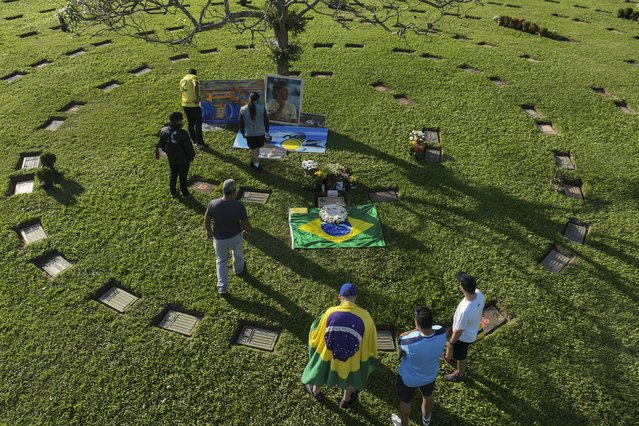 Fans gather at the burial site of late Brazilian Formula One driver Ayrton Senna to mark the 30th anniversary of his death, at Morumbi cemetery in Sao Paulo, Brazil, Wednesday, May 1, 2024. The three-time F1 world champion died in a crash at the Imola race track in San Marino. (Photo by Andre Penner/AP Photo)