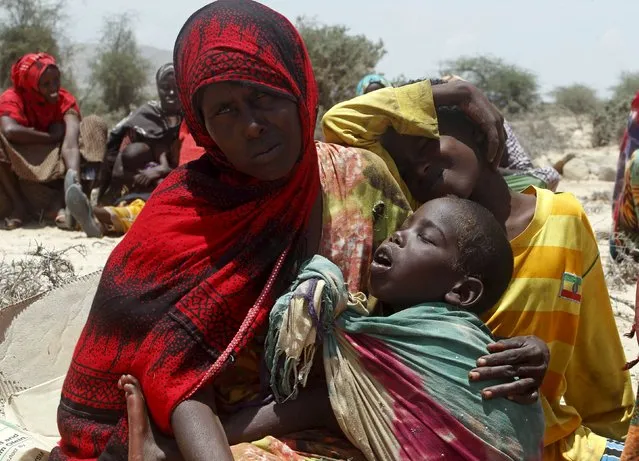 A displaced woman and her children wait for assistance at Habaas town of Awdal region, Somaliland April 9, 2016. (Photo by Feisal Omar/Reuters)