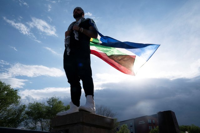 A demonstrator holds a South African flag as he takes part in a protest against former U.S. president Donald Trump, outside the Republican Party of Minnesota’s main fundraising dinner during their convention in St. Paul, Minnesota, U.S., May 17, 2024. (Photo by Erica Dischino/Reuters)