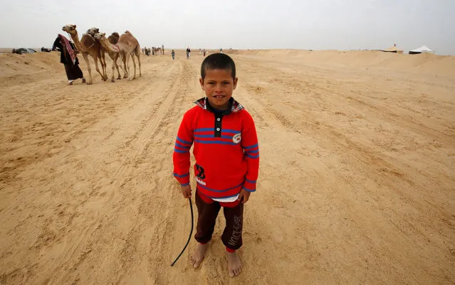 Fahad, an 8-year-old jockey, looks on during the opening of the International Camel Racing festival at the Sarabium desert in Ismailia, Egypt, March 21, 2017. (Photo by Amr Abdallah Dalsh/Reuters)