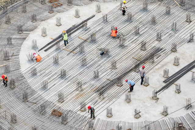 This aerial photo taken on May 29, 2024 shows employees working at the construction site of a grain storage project in Yancheng, in eastern China's Jiangsu province. (Photo by AFP Photo/Stringer)
