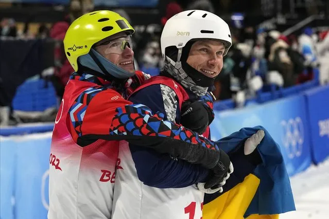 Bronze medal winner Ilia Burov, of the Russian Olympic Committee, left, hugs silver medal winner Ukraine's Oleksandr Abramenko as they celebrate after the men's aerials finals at the 2022 Winter Olympics, Wednesday, February 16, 2022, in Zhangjiakou, China. (Photo by Gregory Bull/AP Photo)
