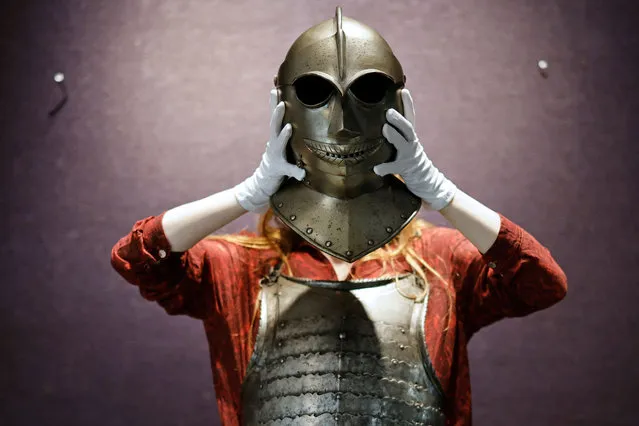 A gallery assistant poses with a Close Helmet of “Savoyard” Type possibly from the 17th Century during a press preview for Bonhams Antique Arms and Armour Sale at Bonhams auction house in central London on May 24, 2021, ahead of the sale on May 26. (Photo by Tolga Akmen/AFP Photo)