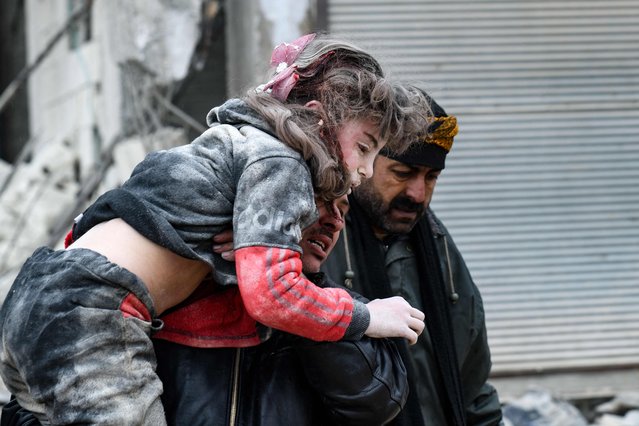 Residents carry an injured child from the rubble of a collapsed building following an earthquake in the town of Jandaris, in the countryside of Syria's northwestern city of Afrin in the rebel-held part of Aleppo province, on February 6, 2023. Hundreds have been reportedly killed in north Syria after a 7.8-magnitude earthquake that originated in Turkey and was felt across neighbouring countries. (Photo by Rami Al Sayed/AFP Photo)