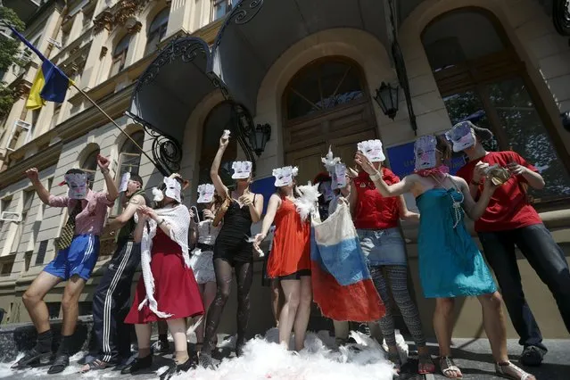 Participants wearing masks stage a satirical performance as they demand a ban on television and radio content that involves Russian actors and singers who support the annexation of Crimea and the self-proclaimed Donetsk People's Republic (DNR) and Luhansk People’s Republic (LNR) in eastern Ukraine, in front of the Culture Ministry headquarters in Kiev, Ukraine, July 8, 2015. (Photo by Valentyn Ogirenko/Reuters)