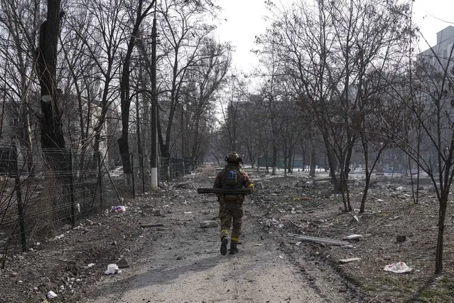 A Ukrainian serviceman walks near the position he was guarding in Mariupol, Ukraine, Saturday, March 12, 2022. (Photo by Evgeniy Maloletka/AP Photo)