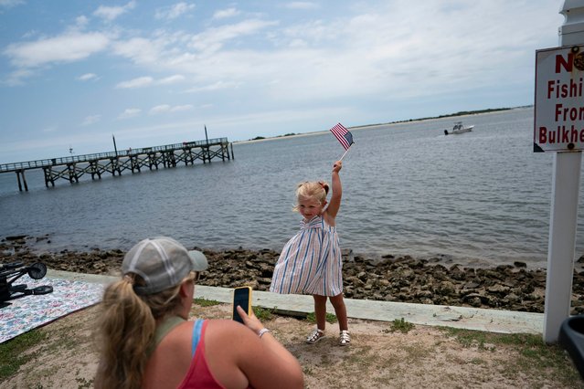 A girl waves a flag after annual Independence Day Parade on July 4, 2024 in Southport, North Carolina. The U.S. Declaration of Independence was signed on this day in 1776, marking the 248th anniversary since the nation's break from Great Britain. The first recorded Independence Day celebration in Southport was in 1795. (Photo by Allison Joyce/Getty Images)