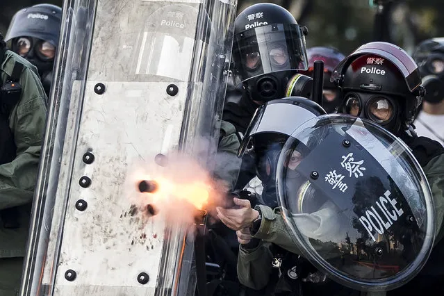 Riot police fire projectiles against protesters in the Sha Tin district of Hong Kong on October 1, 2019, as violent demonstrations take place in the streets of the city on the National Day holiday to mark the 70th anniversary of communist China's founding. Strife-torn Hong Kong on October 1 marked the 70th anniversary of communist China's founding with defiant “Day of Grief” protests and fresh clashes with police as pro-democracy activists ignored a ban and took to the streets across the city. (Photo by Isaac Lawrence/AFP Photo)