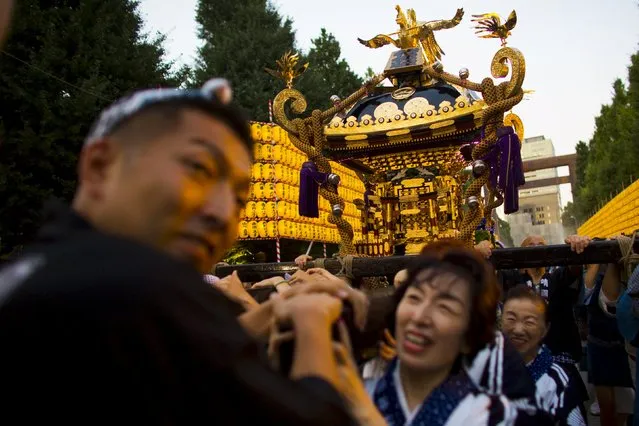 People carry a portable shrine during the annual Mitama Festival at the Yasukuni Shrine in Tokyo, Japan, July 13, 2015. (Photo by Thomas Peter/Reuters)
